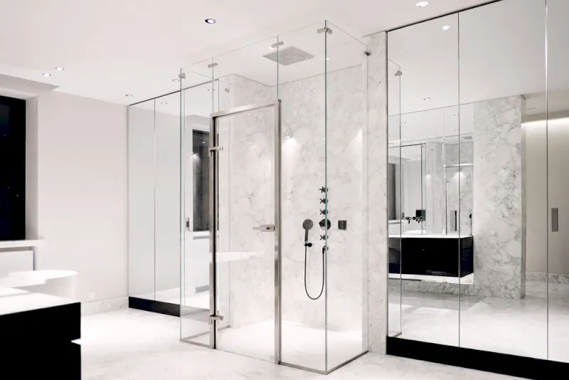 Modernes Bad in Erkrath mit Glasfensterscheiben, einer gläsernen Dusche, Marmorwänden und -böden, Spiegeln und minimalistischen Armaturen. Der Raum ist hell, schlicht und offen und vermittelt ein sauberes, luxuriöses Gefühl.